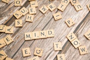 Cognitive Function | Calmly Rooted Scrabble tiles scattered on a wooden surface with the word "MIND" spelled out in the center.