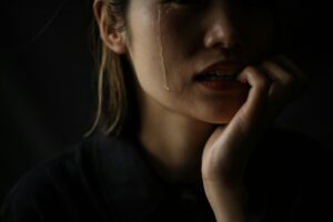 Why Do My Tears Irritate My Skin | Calmly Rooted A woman who bites her nails while crying