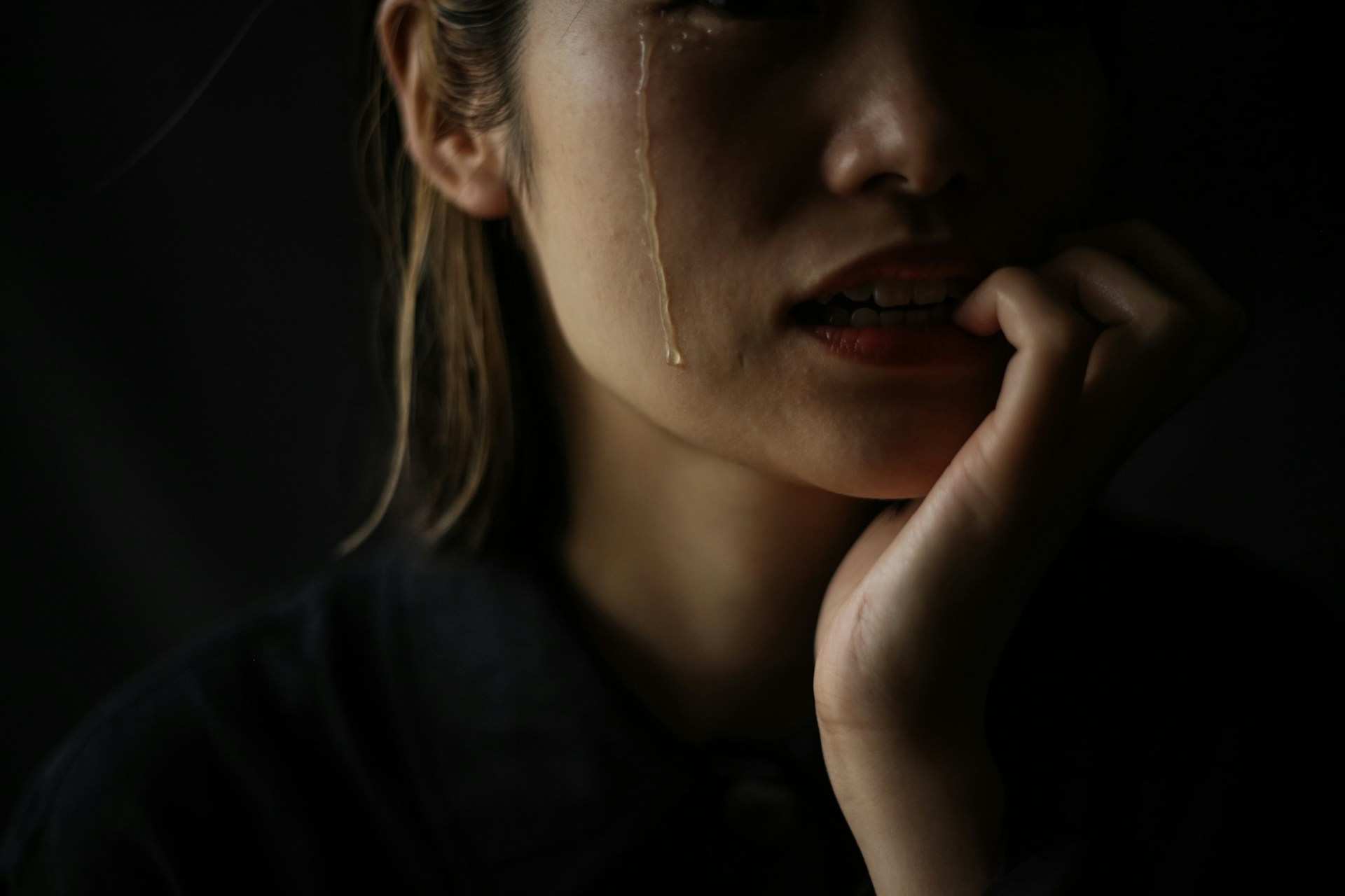 Why Do My Tears Irritate My Skin | Calmly Rooted A woman who bites her nails while crying