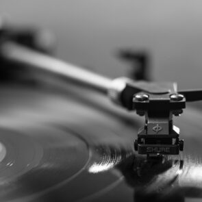 neuroplasticity-music-trivia-calmly-rooted.jpg | Calmly Rooted Close-up of a vintage Shure turntable needle on a vinyl record, representing the connection between music, memory recall, and nervous system regulation.