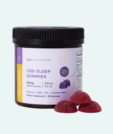 A dark amber jar of Joy Nutrition full-spectrum CBD sleep gummies formulated with melatonin and CBN, with three purple, sugar-coated berry gummies in the foreground, illustrating the ideal CBD gummies before bed.
