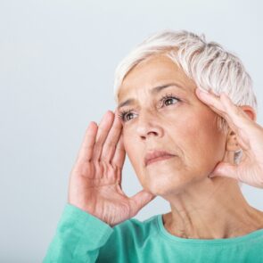 An old woman holding her head