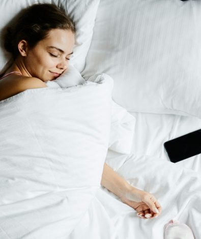 Woman achieving deep sleep recovery with a consistent bedtime ritual, optimized for a high Oura sleep score and HRV at CalmlyRooted.com.