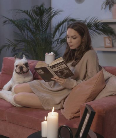 A woman in West Bloomfield MI practicing a 5-minute evening tea ritual on a sofa with MelaMed CBD as part of her sustainable, plant-based relaxation routine for anxiety.